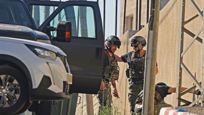 Israeli troops inspect the scene of an exchange of fire in the West Bank city of Nablus in which three Palestinians were killed