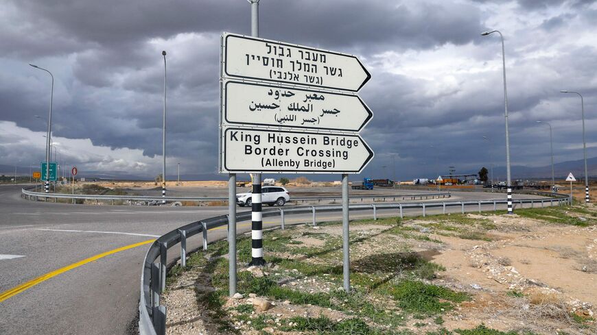 A car drives past a road signal indicating the Allenby (King Hussein) bridge crossing point to Jordan.