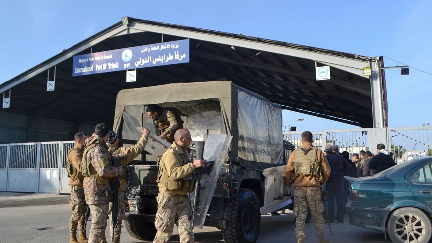 Members of the Lebanese Army deploy as families await news of their relatives at the entrance of the port in the northern city of Tripoli, on the morning of January 1, 2023, following a rescue operation by the navy of a sinking migrant boat in Mediterranean waters, off the Lebanon's northern coast. - Two migrants died and another 200 were rescued when their boat sank off Lebanon's northern coast, from where increasing numbers make the risky journey to flee a collapsed economy. An AFP correspondent in the im