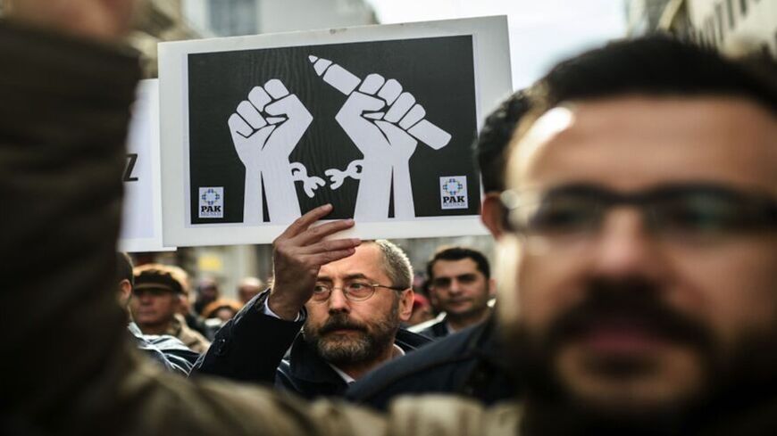 Journalists shout slogans and hold placards on Jan. 10, 2016.