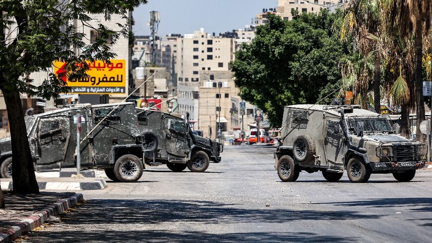 Israeli army vehicles block off a road during a deadly raid on a Palestinian refugee camp in the flashpoint West Bank city of Nablus