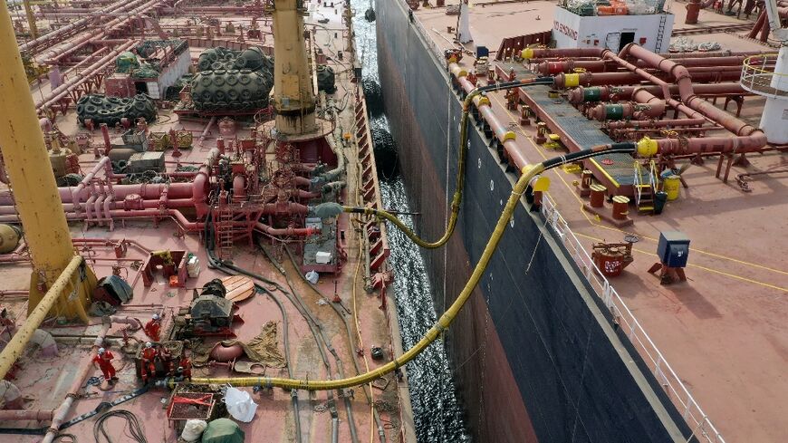 Workers prepare to transfer oil  from the 47-year-old supertanker FSO Safer (L) to a UN-purchased replacement vessel in a bid to avert a catastrophic spill in the Red Sea off war-torn Yemen