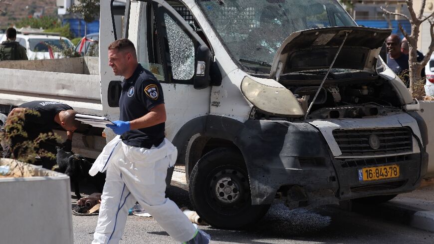 Israeli forensic officers inspect a bullet-riddled truck next to a checkpoint outside the Palestinian village of Nilin following a ramming attack 