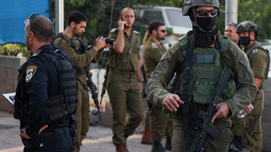 Israeli security forces stand guard at the car wash in the West Bank town of Huwara where two Israeli civilians were shot dead in an attack