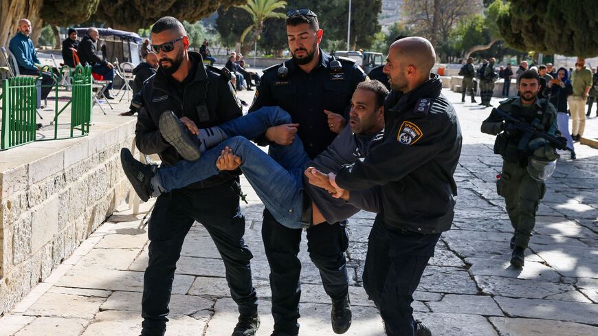 Israeli policemen detain a Palestinian man at the Al-Aqsa Mosque compound following clashes that erupted during the Islamic holy fasting month of Ramadan in Jerusalem on April 5, 2023.