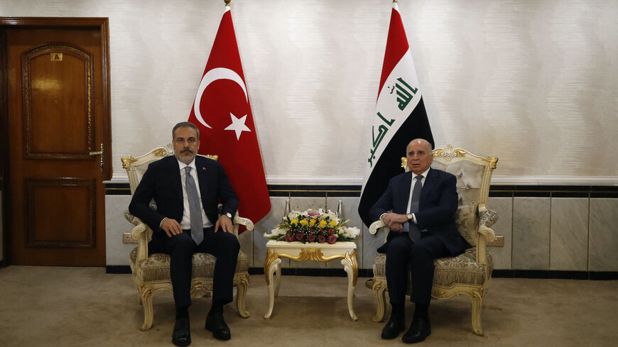 Iraq's Foreign Minister Fuad Hussein (R) poses with Turkey's Foreign Minister Hakan Fidan in Baghdad on Aug. 22, 2023.