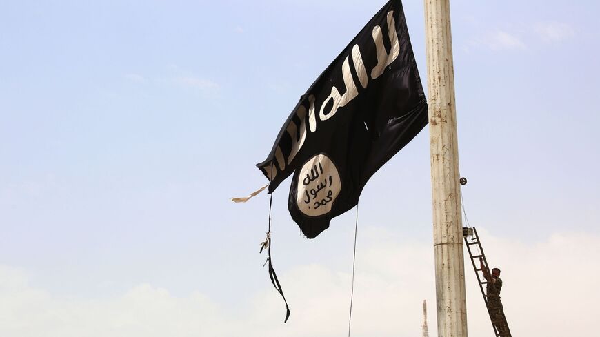 A member of the US-backed Syrian Democratic Forces (SDF), made up of an alliance of Arab and Kurdish fighters, removes an Islamic State group flag in the town of Tabqa, about 55 kilometres (35 miles) west of Raqa city, on April 30, 2017.