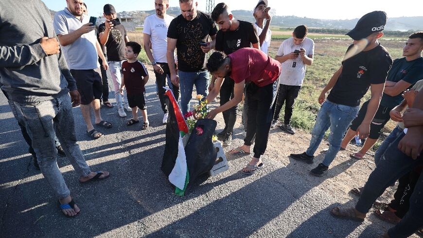 Mourners lay roses at the site where three Palestinians were killed by Israeli forces near Jenin camp in the occupied West Bank