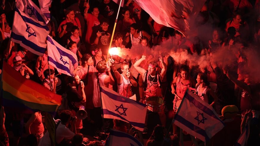 Protesters brandish flares during the latest protest against the Israeli government's controversial judicial reform plans