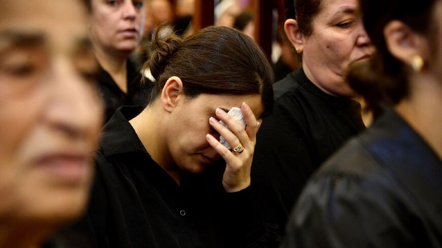 Iraqi mourners attend a mass for the victims of a wedding hall fire at a church in Qaraqosh