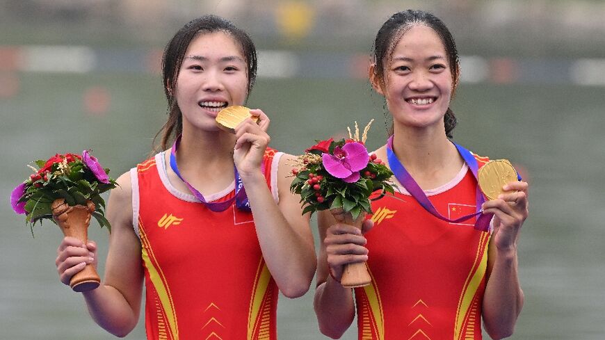 Gold medallists Zou Jiaqi and Qiu Xiuping of China celebrate their win