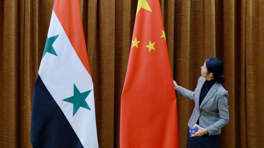 A Foreign Ministry staff member arranges the Chinese flag before an official visit, Beijing, December 24, 2015.