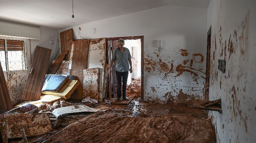 A man inspects a mud covered room in a house in the eastern Libyan city of Susa