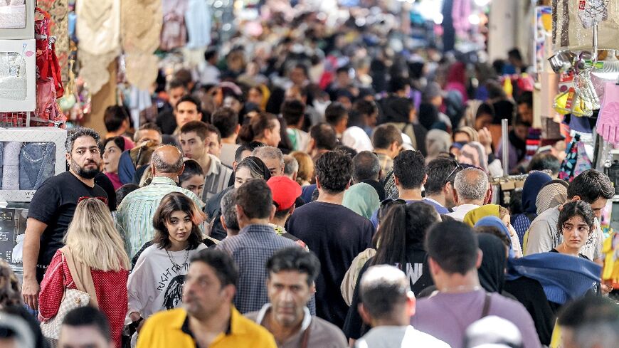 People walk at the Grand Bazaar in Tehran on September 5, 2023