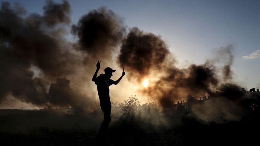 Palestinian demonstrators burn tyres during clashes with Israeli soldiers along the Gaza-Israel border