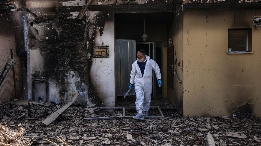 A volunteer of the Zaka emergency response team searches through the debris in Kibbutz Beeri near the border with Gaza on October 20, 2023