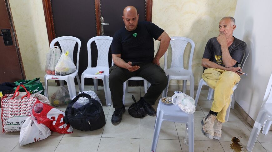 Palestinians from Gaza stranded in the Israeli-occupied West Bank, follow the news in a hotel room in Ramallah 