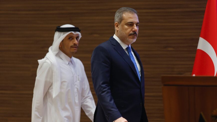 Qatari Prime Minister and Foreign Minister Mohammed bin Abdulrahman al-Thani (L) addresses a joint press conference with visiting Turkish Foreign Minister Hakan Fidan