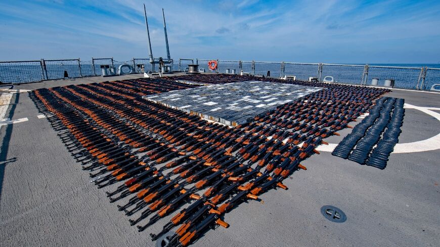 A handout photo released on December 22, 2021 by the US Defense Department shows AK-47 rifles and ammunition seized by the US navy from a fishing boat in the North Arabian Sea