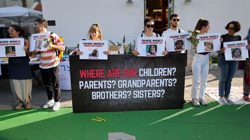 People carry placards bearing pictures of missing persons as they protest for the release of Israelis held hostage by Hamas militants in the Gaza Strip, outside the Ministry of Defence in Tel Aviv on October 19, 2023.