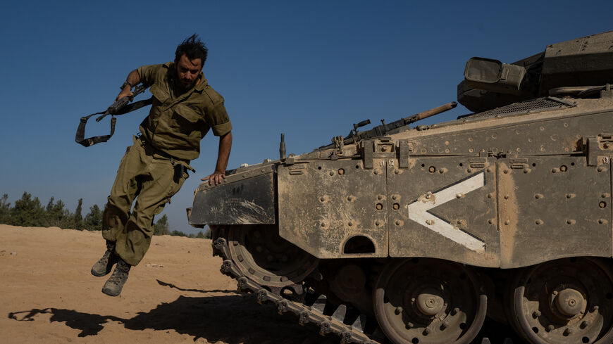 SOUTHERN ISRAEL - OCTOBER 21: An IDF soldier jumps off the front of a tank on October 21, 2023 in Southern Israel. Today marks two weeks since the kibbutzim and communities around the Gaza border, as well as the Super Nova party a were attacked by Hamas militants. As Israel prepares to invade the Gaza Strip in its campaign to vanquish Hamas, the Palestinian militant group that launched a deadly attack in southern Israel on October 7th, worries are growing of a wider war with multiple fronts, including at th