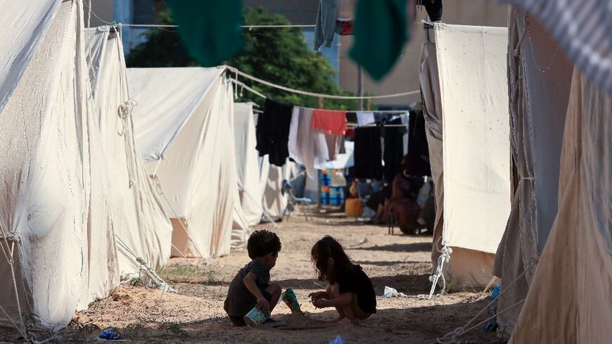 Children play among tents pitched on UN premises in Khan Yunis where their parents hope there may be some refuge from Israel's retaliatory bombardment of the Hamas-ruled Gaza Strip