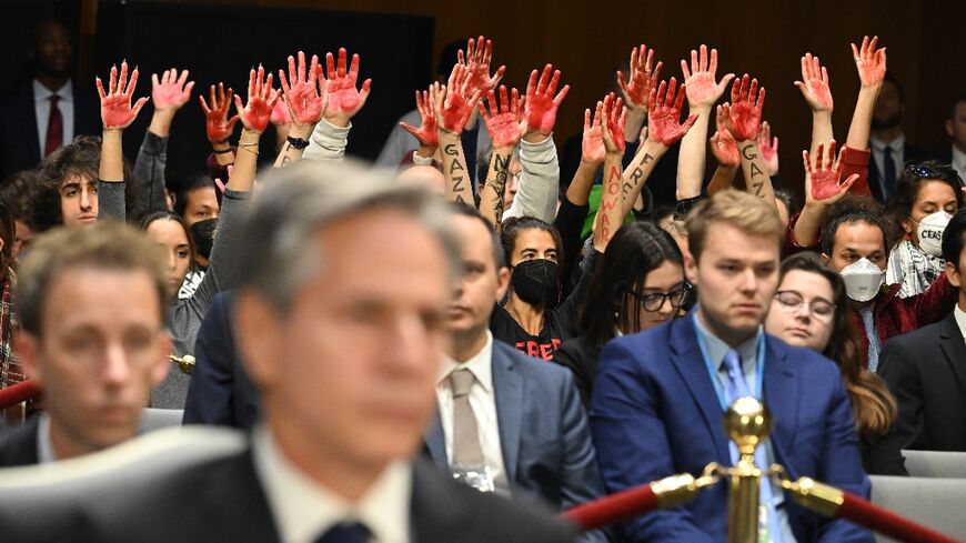 Protesters raise their painted hands as US Secretary of State Antony Blinken testifies during a Senate Appropriations Committee hearing to examine the national security supplemental request, in Washingotn October 31, 2023