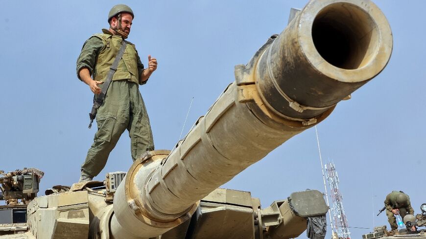 An Israeli soldier stands on the turret of a tank near the city of Sderot across the border with as Israel vows to destroy Hamas militants in the coastal enclave