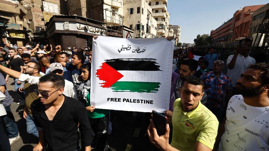 Egyptians hold up pro-Palestinian placards at a rally in solidarity with Gaza in the capital Cairo