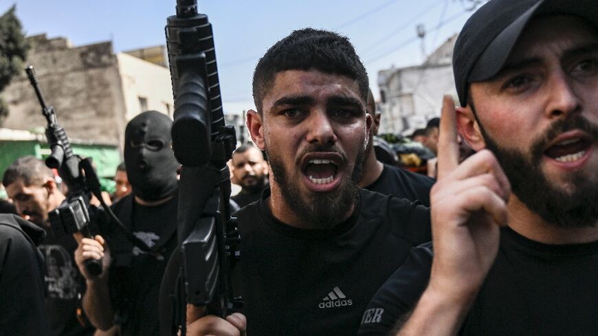 Armed Palestinians join the funeral procession for three militants killed in an overnight raid by the Israeli army on Jenin refugee camp in the occupied West Bank