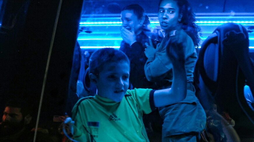 Hostages released by Hamas are seen through the window of a bus transporting them to an army base in Ofakim, southern Israel, in the third phase of the releases