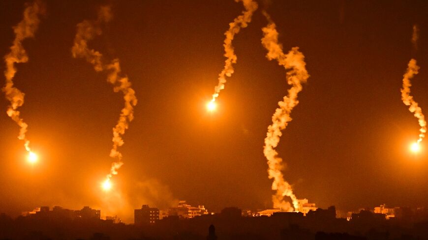 This picture taken from a position near Sderot along the Israeli border with the Gaza Strip on November 5, 2023, shows flares dropped by Israeli forces above the Palestinian territory