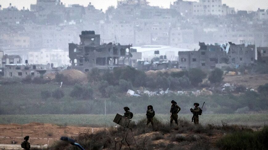 This picture taken from a position along the border with the Gaza Strip in southern Israel shows Israeli soldiers amid ongoing battles with the Palestinian militant group Hamas, on November 14, 2023