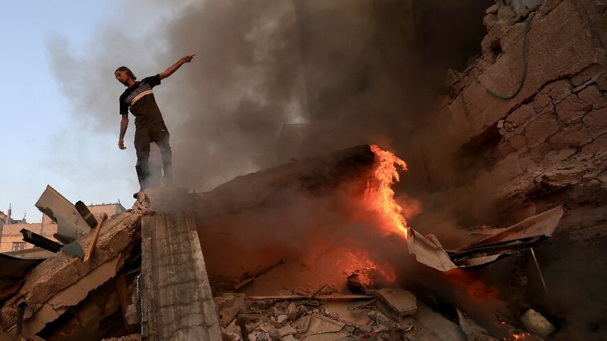 A man stands on the rubble of a collapsed building after a strike on Khan Yunis on November 4