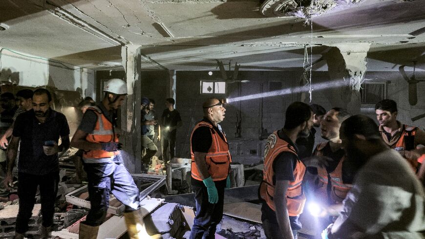 Rescuers search the home of Palestine TV journalist Mohammed Abu Hatab after he and members of his family were killed