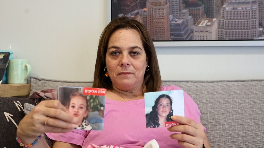 Maayan Zin shows pictures of her daughters Ela, 8, and Dafna, 15, who are believed to be among the hostages  Hamas militants took during the October 7 attack