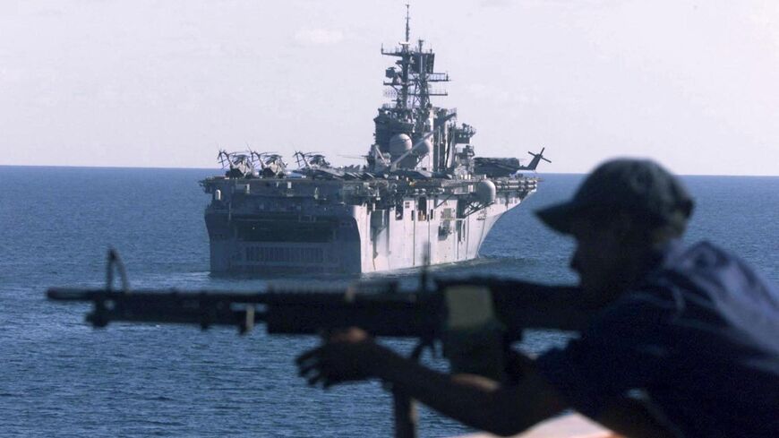 A Navy member of the Quick Acting Response Team scans the horizon as he protects the USS Whidbey Island and the USS Bataan.