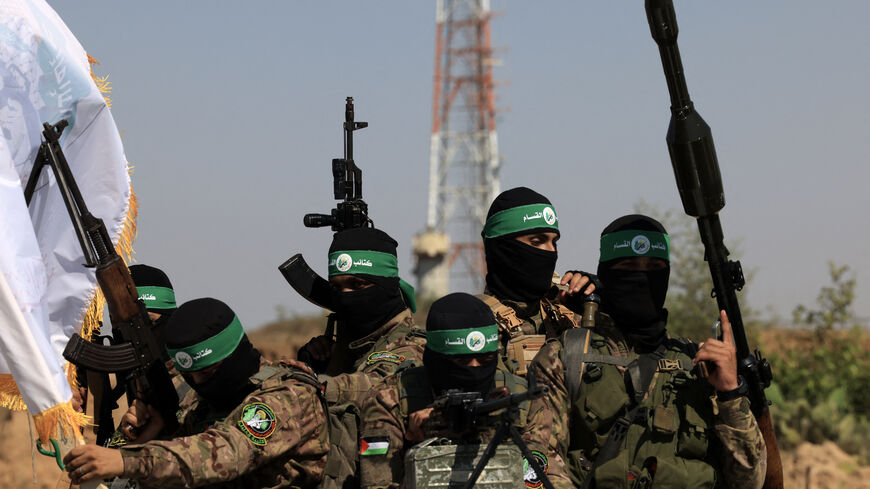 Palestinian fighters of the al-Qassam Brigades, the armed wing of the Hamas movement, take part in a military parade to mark the anniversary of the 2014 war with Israel, near the border in the central Gaza Strip on July 19, 2023. (Photo by MAHMUD HAMS / AFP) (Photo by MAHMUD HAMS/AFP via Getty Images)