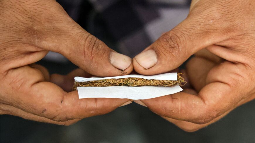 A man rolls a cigarette of processed tobacco leaves, Jalamah, Aleppo province, Syria, Sept. 5, 2023.