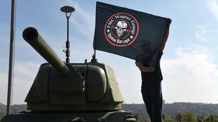 A man poses with a flag of Wagner group.