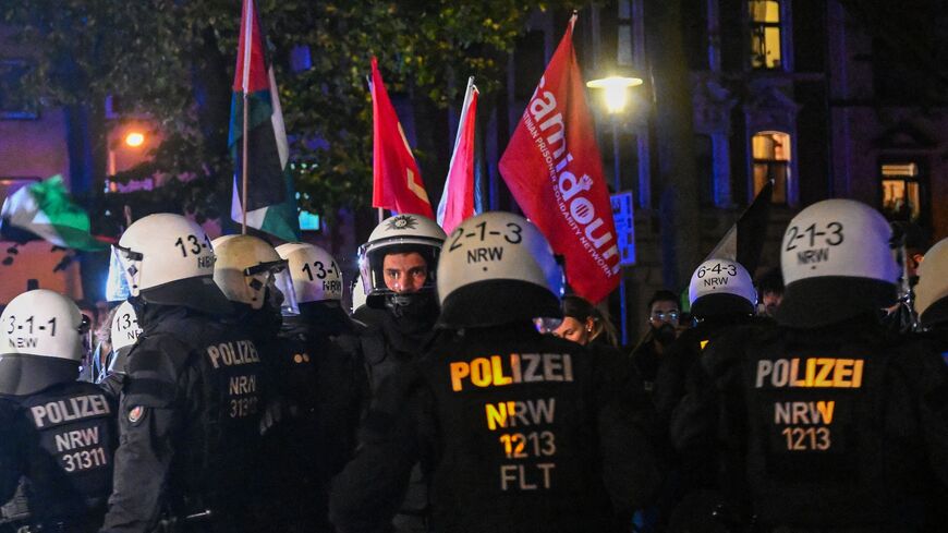 German police officers stand in front of a flag of the Palestinian prisoner organization Samidoun during a demonstration in Duisburg, Oct. 9, 2023.