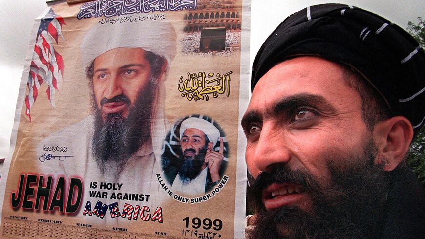 A religious protester holds a portrait of Saudi dissident Osama bin Laden during a protest rally against the United States on July 30, 1999, in Islamabad. 