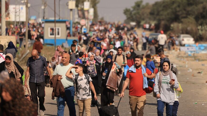 Palestinians families fleeing Gaza City and other parts of northern Gaza walk along a highway 