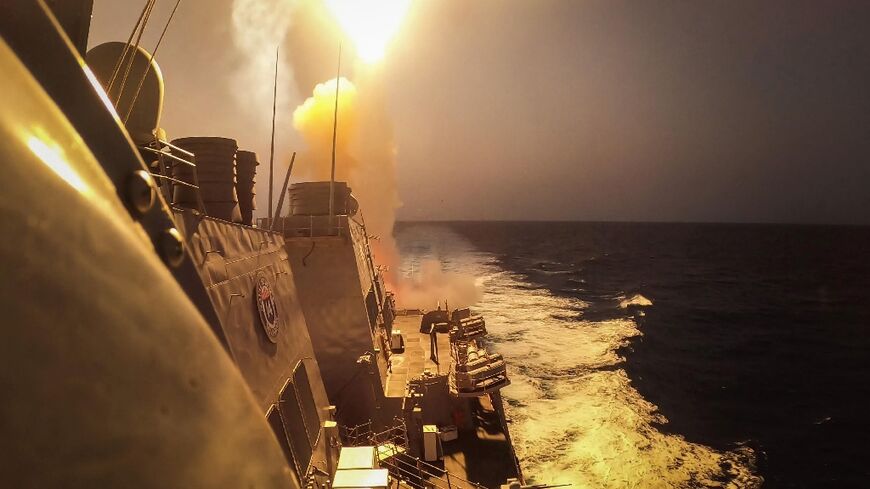 A handout picture courtesy of the US Navy shows the guided missile destroyer USS Carney firing on missiles and drones launched from Yemen on October 19, 2023