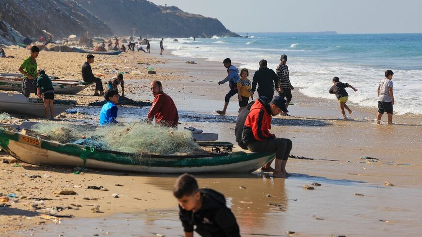 Palestinians flock to Deir el-Balah beach in the central Gaza Strip, taking advantage of a pause in fighting between Israel and Hamas to bathe or fish