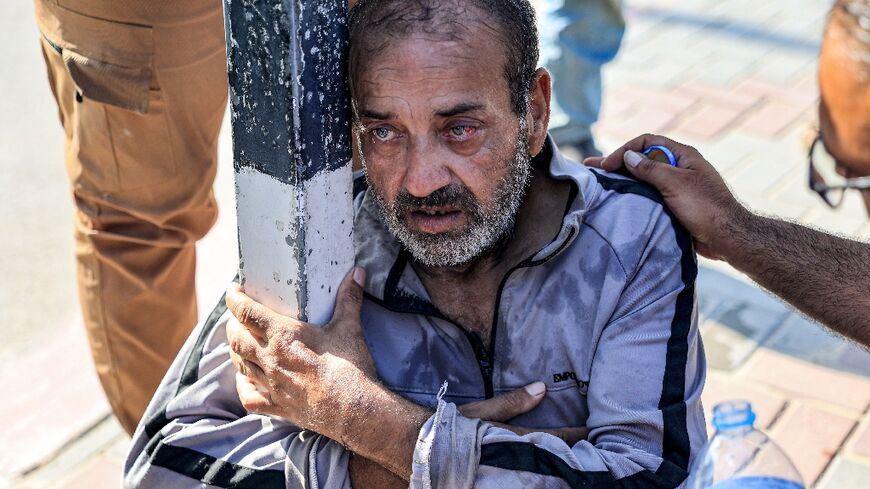 A Palestinian worker collapses after returning to Gaza