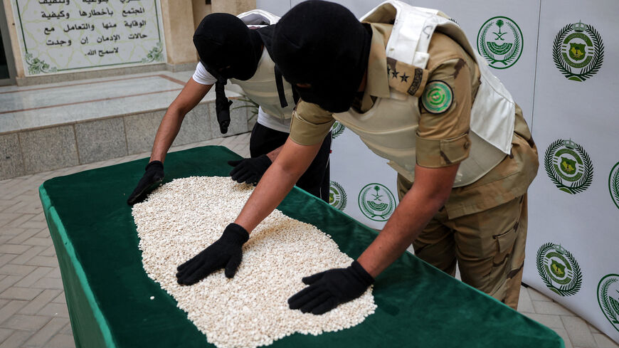 Officers of the Directorate of Narcotics Control of Saudi Arabia's Interior Ministry sort through tablets of captagon (Fenethylline) seized during a special operation and presented before AFP afterward in the Red Sea coastal city of Jeddah on March 1, 2022.