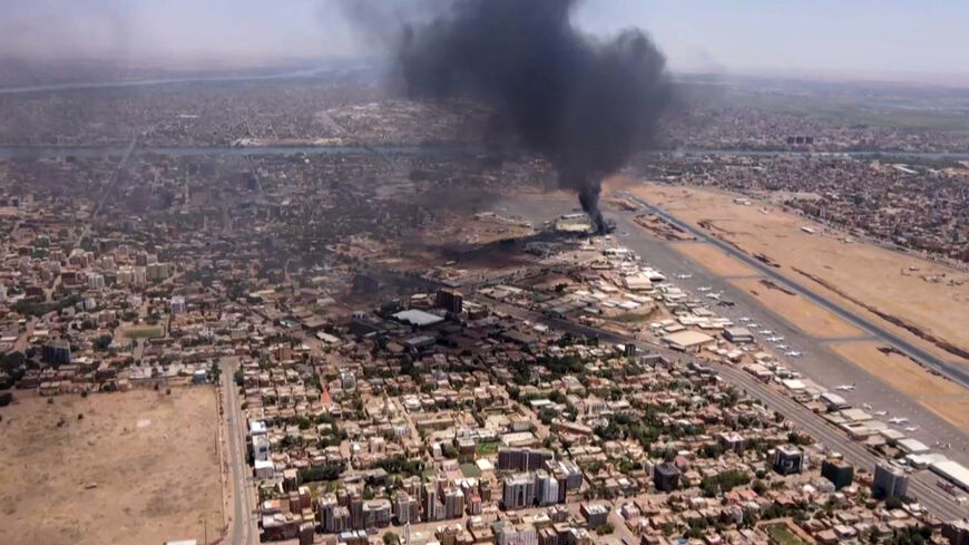 This image grab taken from AFPTV video footage on April 20, 2023, shows an aerial view of black smoke rising above the Khartoum International Airport amid ongoing battles between the forces of two rival generals. 