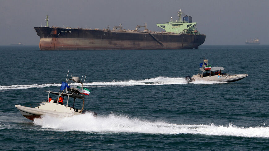 Islamic Revolutionary Guard Corps speedboats cruise past an oil tanker off the port of Bandar Abbas, southern Iran, on July 2, 2012.