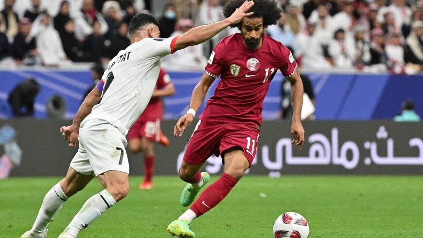 Qatar's forward #11 Akram Afif and Palestine's defender #07 Musab al-Battat during the match between Qatar and Palestine